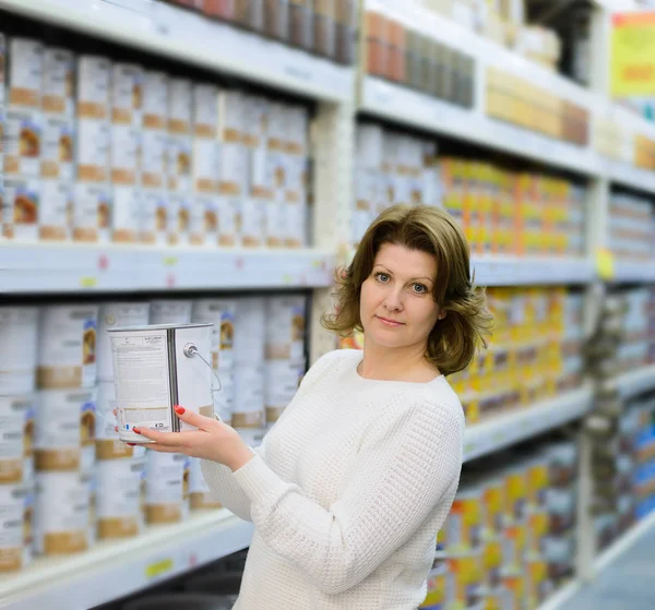 Женщина выбирает краску в магазине — стоковое фото