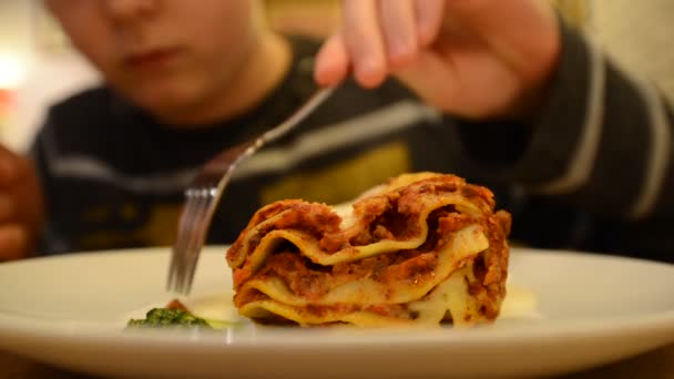 Boy is eating a lasagna in a cafe — Stock Video