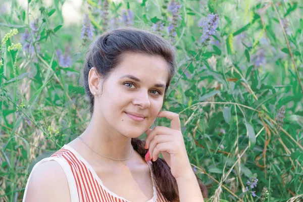 Portret van mooi Russisch meisje op achtergrond van blauwe wilde bloemen — Stockfoto