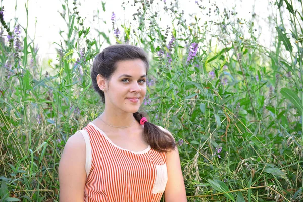 Portret van mooi Russisch meisje op achtergrond van blauwe wilde bloemen — Stockfoto