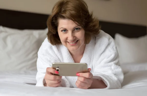 ホテルの部屋で電話がバスローブで女性の身に着けています。 — ストック写真