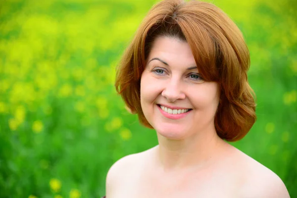 Portrait of smiling middle-aged woman with bare shoulders — Stock Photo, Image