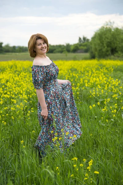 Donna di mezza età in piedi sul prato estivo — Foto Stock