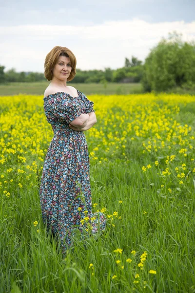 Middle-aged woman standing on summer meadow — Stock Photo, Image