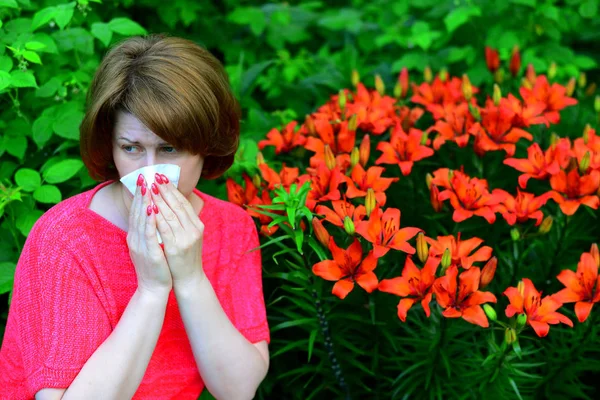 Femme avec une rhinite allergique près des lis dans la nature — Photo