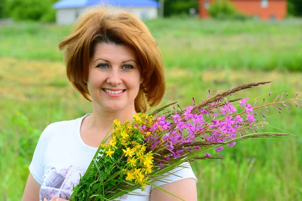 Donna con mazzo di fiori di campo sulla natura — Foto Stock