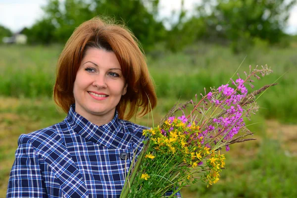 Donna con mazzo di fiori di campo sulla natura — Foto Stock