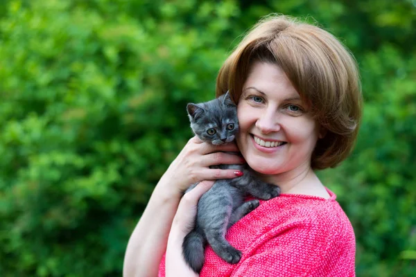 Woman hugging a blue kitten Scottish strait in outdoors — Stock Photo, Image