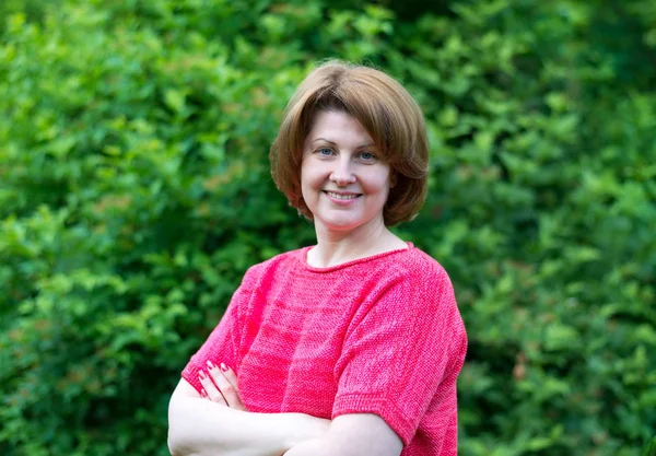 Portrait of middle-aged woman in red clothes outdoors — Stock Photo, Image