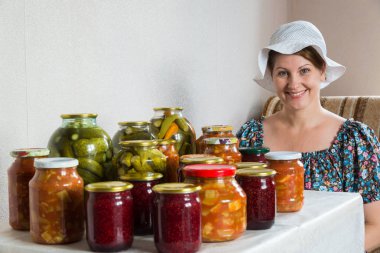 kadın ev yapımı sebze konserveleri ve reçel de masada oturur