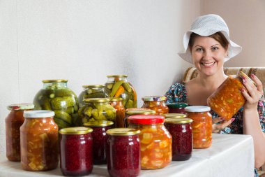 kadın ev yapımı sebze konserveleri ve reçel de masada oturur