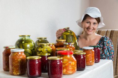 kadın ev yapımı sebze konserveleri ve reçel de masada oturur