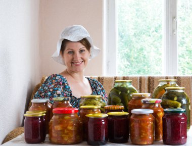kadın ev yapımı sebze konserveleri ve reçel de masada oturur