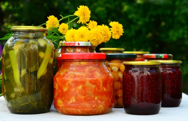 Багато домашніх консервованих овочів і варення в скляних банках — стокове фото