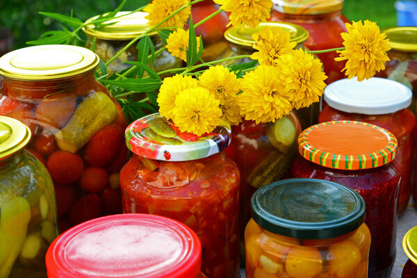 Lot of homemade canned vegetables and jam in glass jars