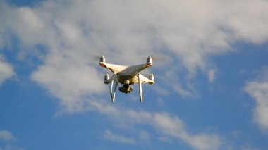 Beyaz insansız hava aracı bir gökyüzü karşı uçar