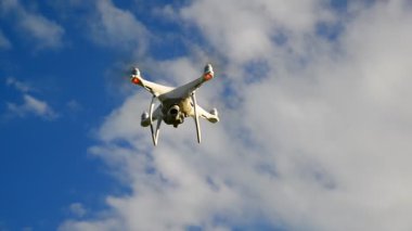 Beyaz insansız hava aracı bir gökyüzü karşı uçar