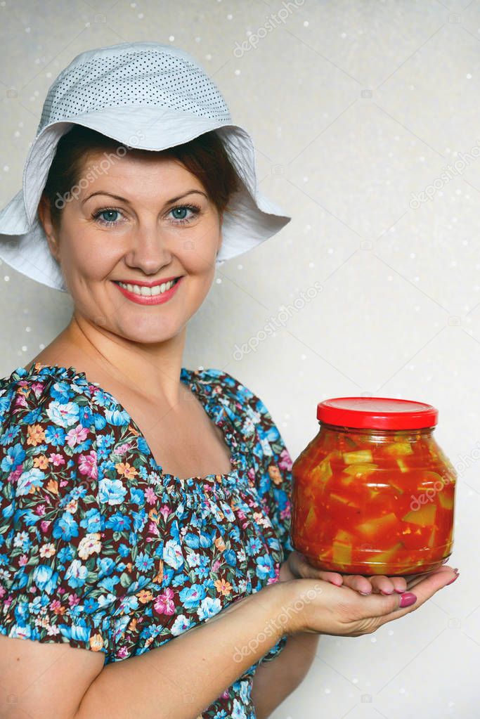 Woman holding a jar of canned vegetables with zucchini