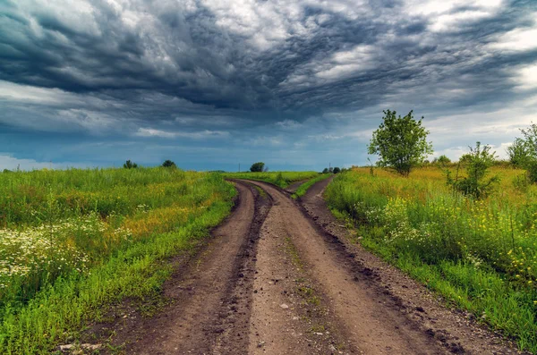 Paisaje rural con carretera y cielo tormentoso —  Fotos de Stock