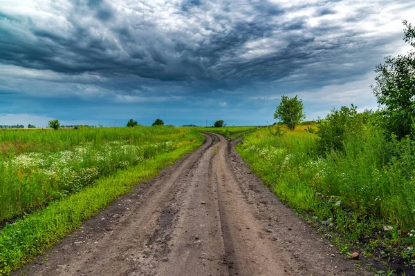 Paisaje rural con carretera y cielo tormentoso —  Fotos de Stock