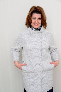 Duvar arka planı beyaz dantel palto kadında standları