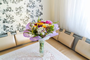 Odasında masaya çiçek buketi