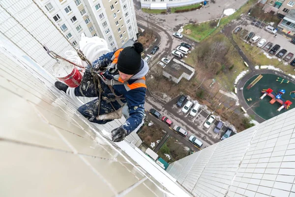 Bergsteiger Mitarbeiter der Stadtwerke wärmt Fassade von Wohnhaus. — Stockfoto