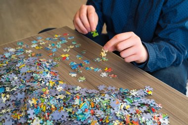 Bir genç bulmacalar bir sehpa üzerinde toplar..