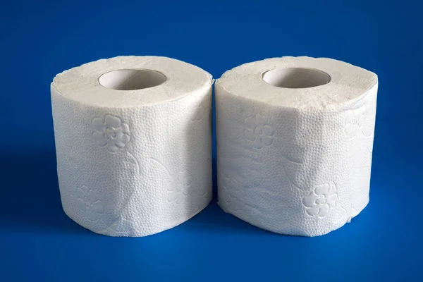 Dos rollos de papel higiénico blanco y suave sobre fondo azul —  Fotos de Stock
