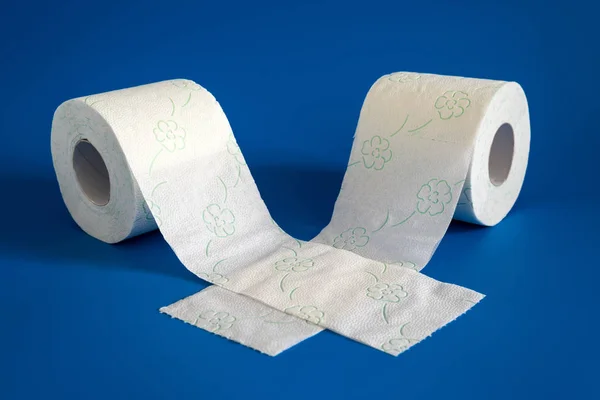 Dos rollos de papel higiénico blanco y suave sobre fondo azul —  Fotos de Stock