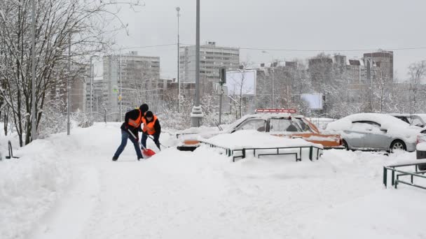 Москва, Россия - 4 февраля. 2018 год. Рабочие убирают снег лопатами и тракторами — стоковое видео