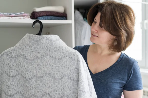 Женщина выбирает одежду в гардеробе в квартире — стоковое фото