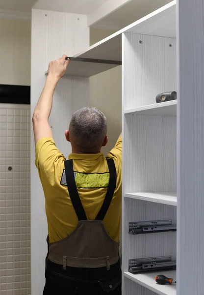 The master installs a wardrobe in apartment — Stock Photo, Image