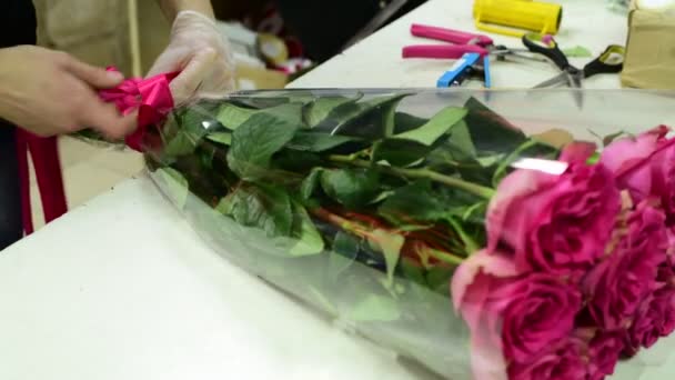 Florist binda band på en bukett med rosa rosor — Stockvideo