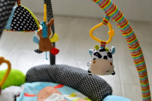 Mainan untuk bayi yang baru lahir tergantung di atas karpet — Stok Foto