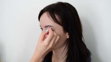 visagiste kaşlar genç esmer kız boyar.