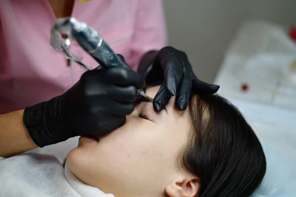 Master does tattoo on eyebrows to girl. — Stock Photo, Image