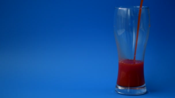 El jugo de tomate se vierte en un vaso en cámara lenta — Vídeo de stock