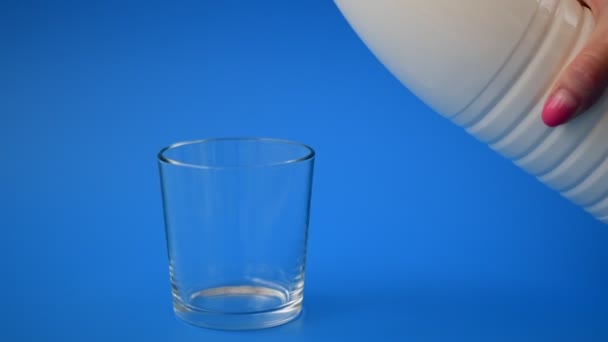 Milk is poured from bottle into the glass in slow motion — Stock Video