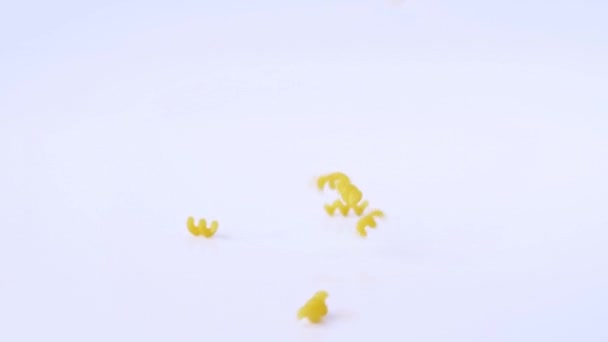 Kuru makarna yavaş beyaz arka plan üzerinde strewed — Stok video