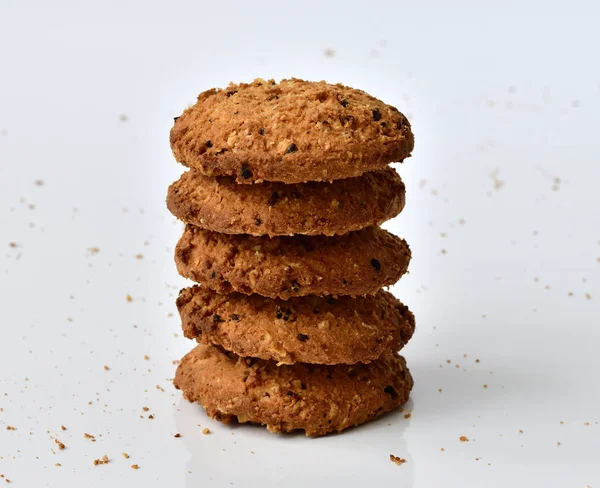 Stack of oatmeal cookies on light background and crumbs — Stock Photo, Image