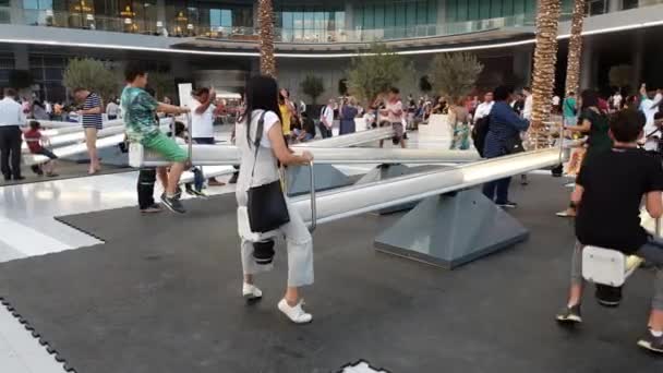 Dubai, Verenigde Arabische Emiraten - 8 April. 2018. de mensen rijden op schommel in plein van Dubai Mall — Stockvideo