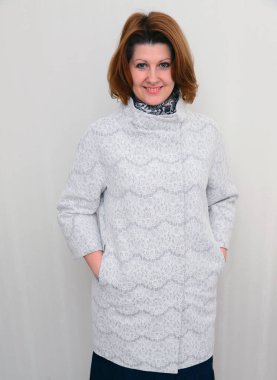 Duvar arka planı beyaz dantel palto kadında standları