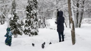 Moscow, Rusya Federasyonu - 31 Ocak. 2018. anne ve kızı karda güvercin beslemek.
