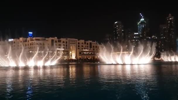 Dubai, Birleşik Arap Emirlikleri - 8 Nisan. 2018. Uluslararası Dubai Kongre ve Sergi Sarayı gölde geceleri çeşme — Stok video