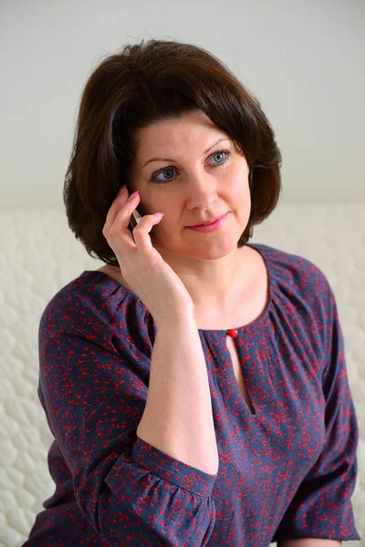 Woman talking on phone in her room — Stock Photo, Image