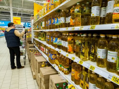 Moskova, Rusya - 14 Nisan. 2018. alıcı ayçiçek yağı Auchan deposunda seçer.