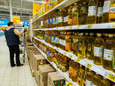 Moscow, Russia - April 14. 2018. buyer chooses sunflower oil in the Auchan store clipart