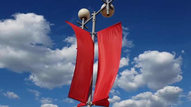 Κόκκινες σημαίες που λικνίζονται στον άνεμο κατά το γαλάζιο του ουρανού. — Αρχείο Βίντεο