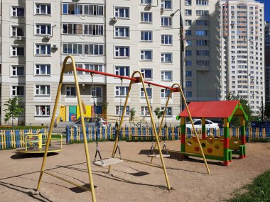 şehirde bir konut binanın avlusundaki Çocuk Bahçesi ile sallanır